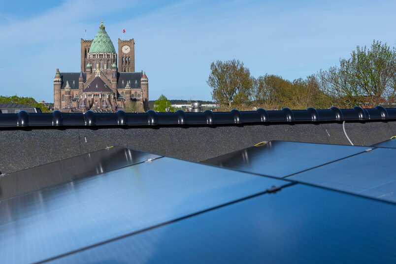 solar panels on roof with cathedral in background